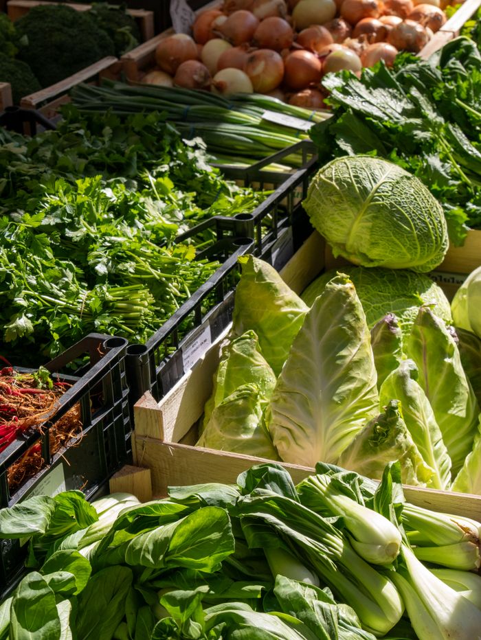 A vibrant display of fresh organic vegetables at an outdoor market, showcasing green produce.
